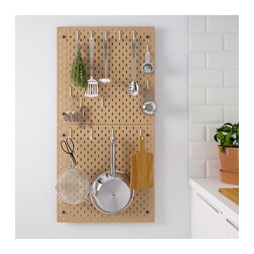 a peg board with pots, pans and utensils hanging on the wall