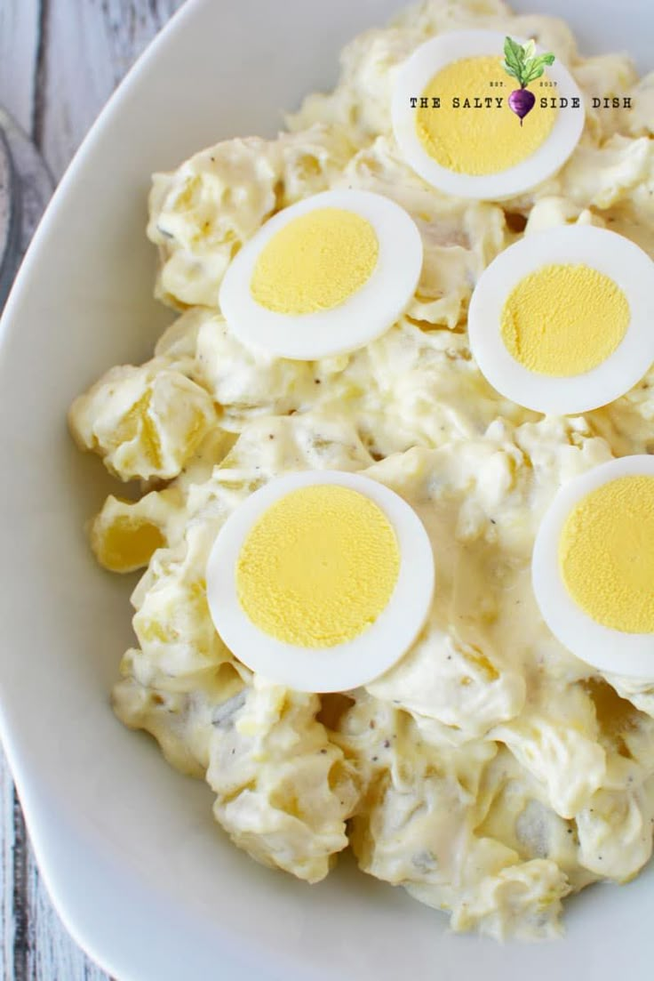 an egg salad on a white plate with four hard boiled eggs in the middle,