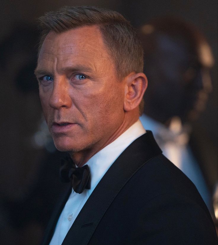 a man in a tuxedo looks off into the distance