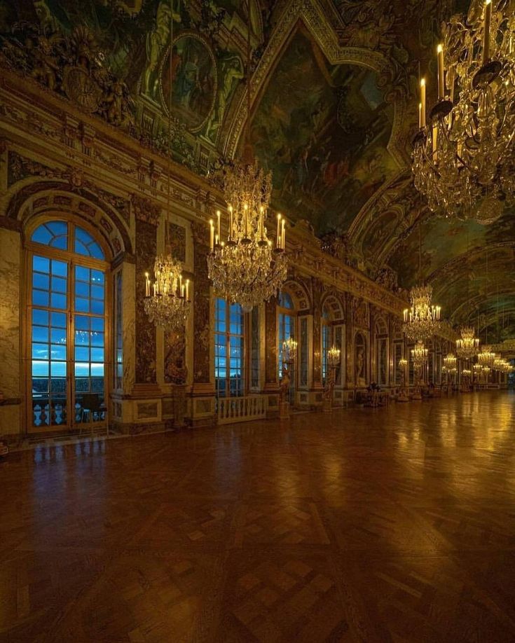 an empty ballroom with chandeliers and large windows