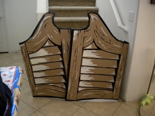 a cardboard cutout of a wooden gate on the floor in front of a stair case