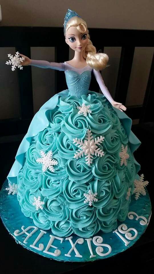 a barbie doll cake with blue frosting and snowflakes