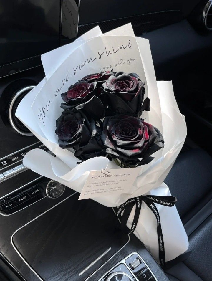 a bouquet of roses sitting on top of a car dashboard