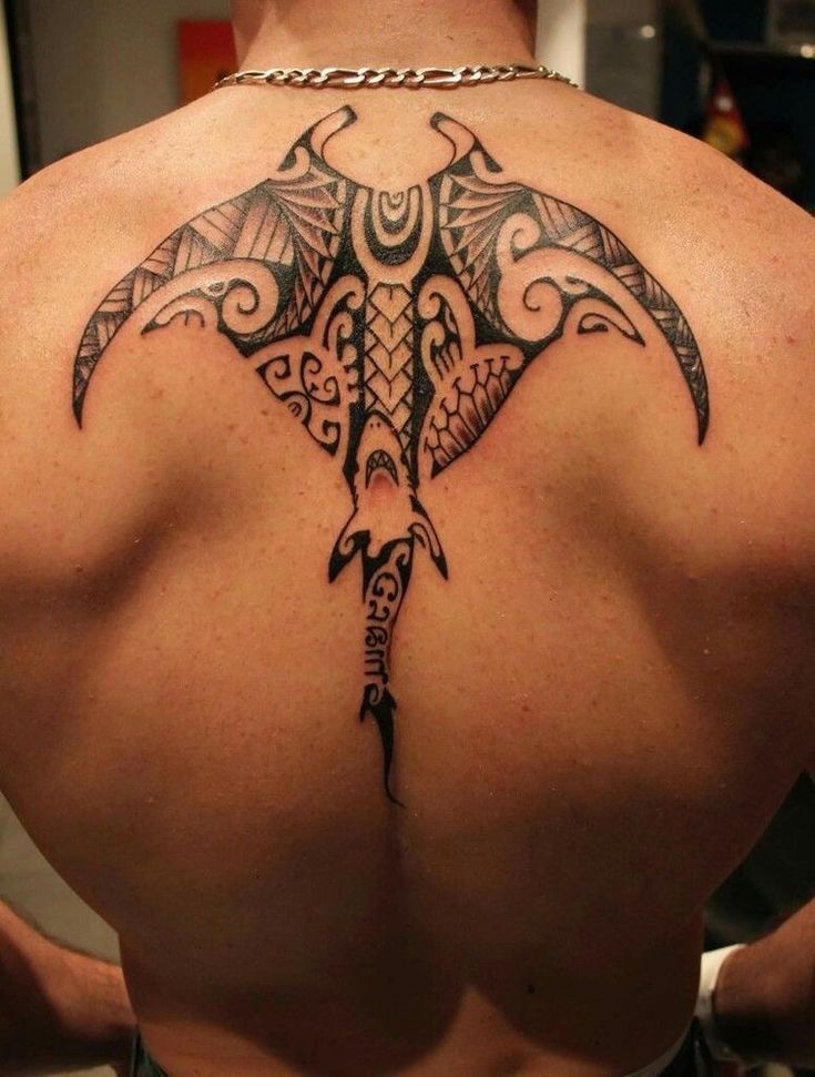 a man's back with an intricate tattoo design on his upper and lower back