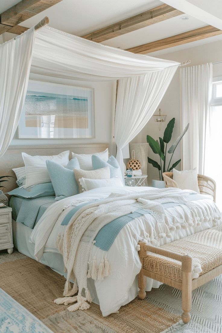 a bed with white and blue sheets in a bedroom next to a window, wicker chair