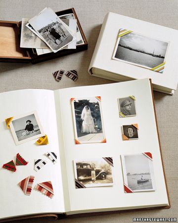 an open book sitting on top of a table filled with pictures and photos next to a wooden box