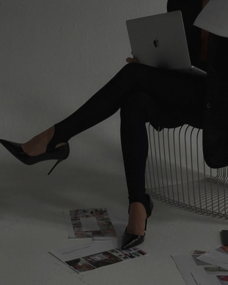 a woman is sitting on the floor with her legs crossed and holding a laptop computer