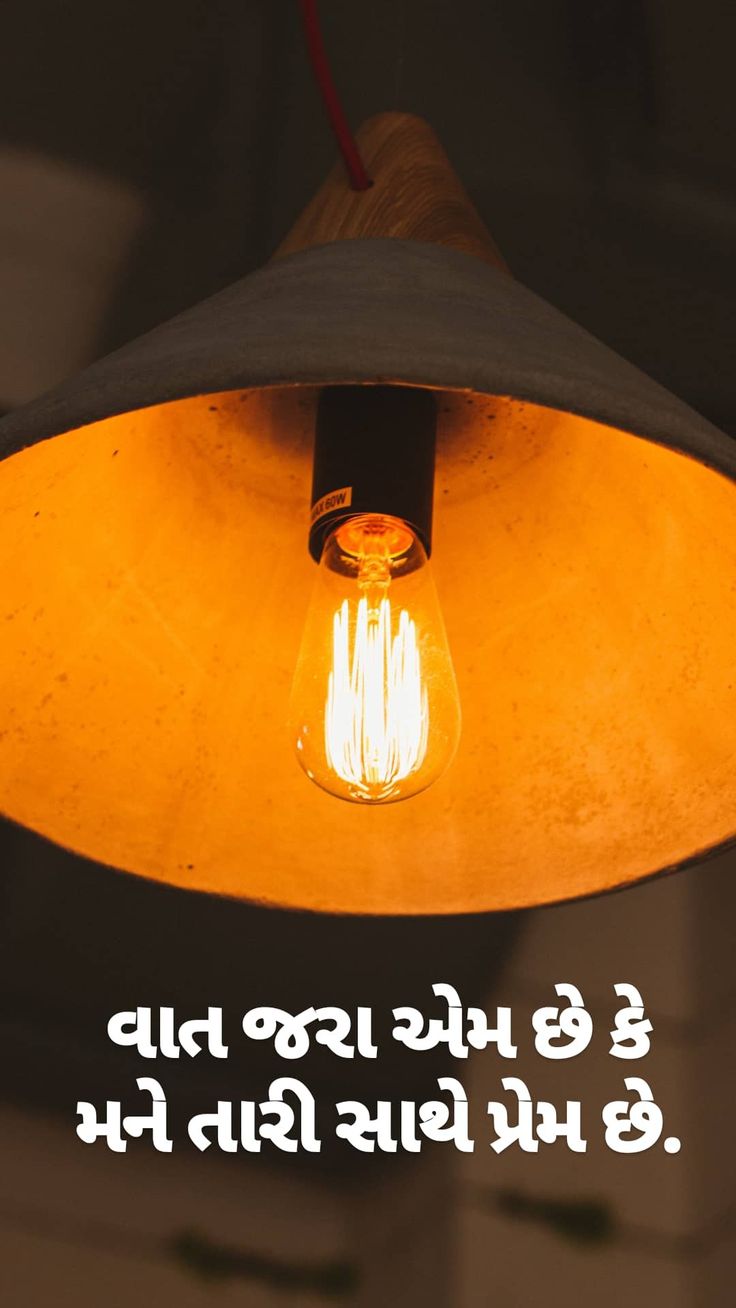 an orange light bulb hanging from a ceiling with the words in english and arabic on it