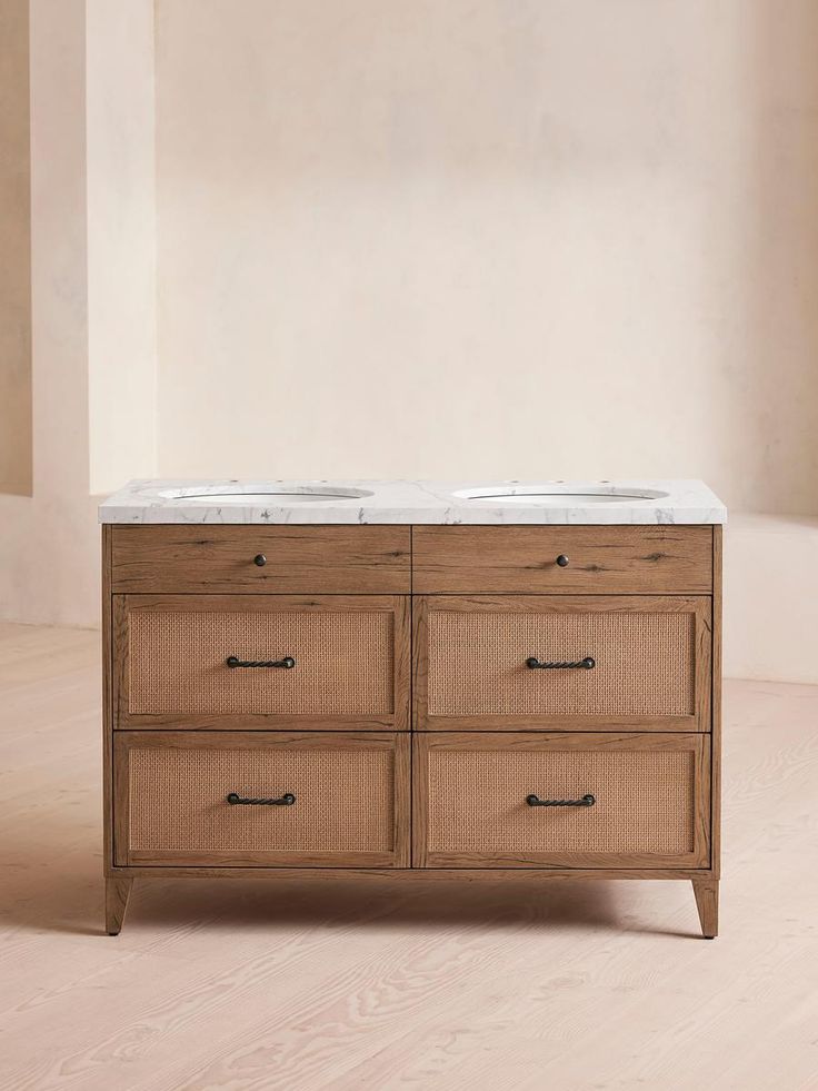 a bathroom vanity with marble top and two sinks in the same color as it stands against a beige wall