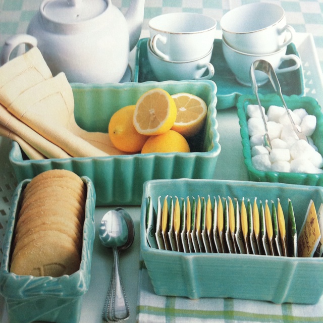 a table topped with dishes and cups filled with food