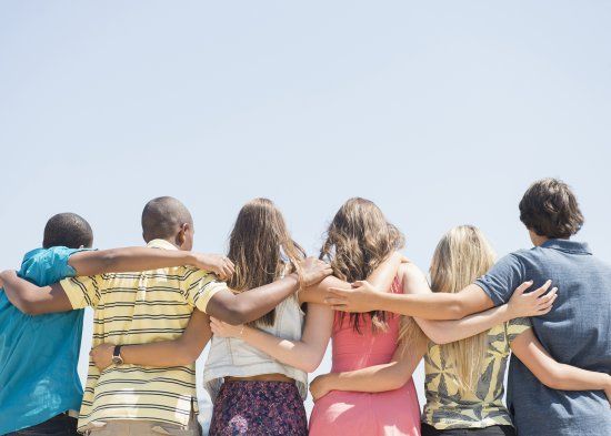 a group of people standing together with their arms around each other and the words coming together is a beginning keeping together is progress