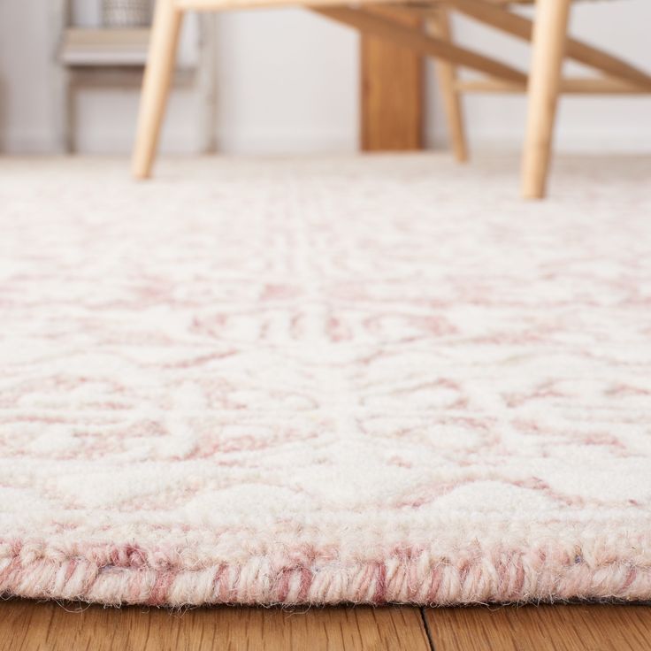 a white rug on the floor in a room with wooden chairs and a table behind it