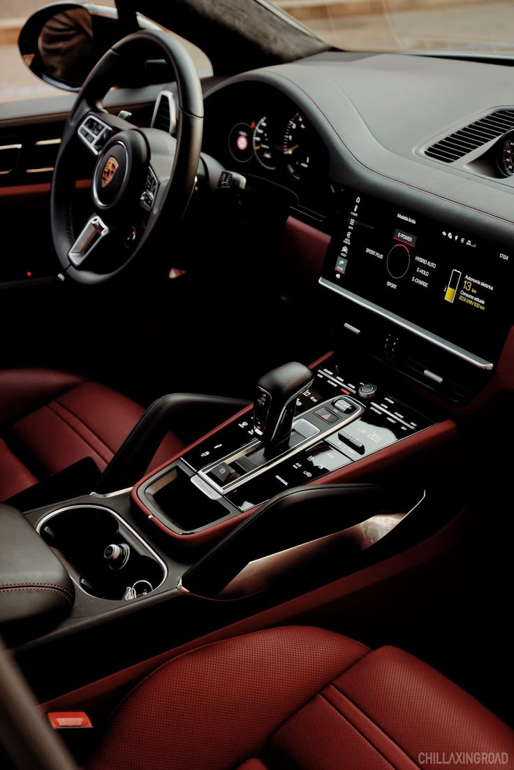 the interior of a sports car with red leather and black trims, including steering wheel