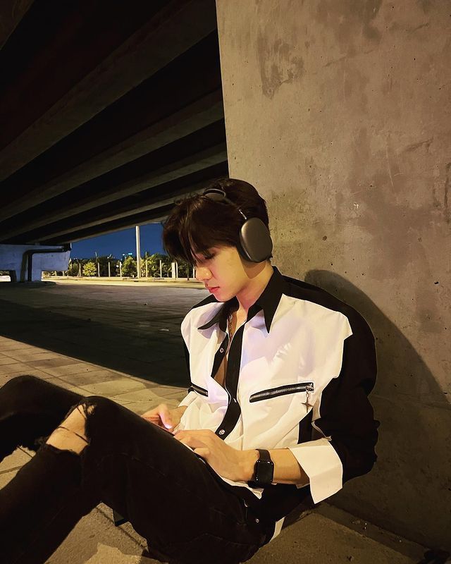 a person sitting on the ground wearing headphones