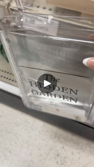 a person holding a clear plastic container with the label on it in front of a store shelf