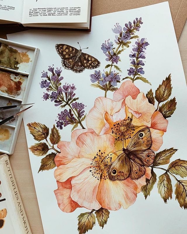 a painting of flowers and butterflies on a table with paintbrushes next to it