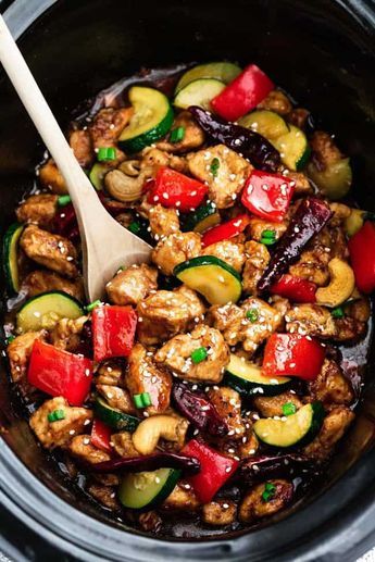 a slow cooker filled with chicken, peppers and zucchini in the crock pot