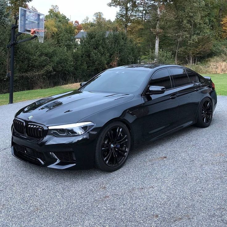 a black bmw is parked in the parking lot