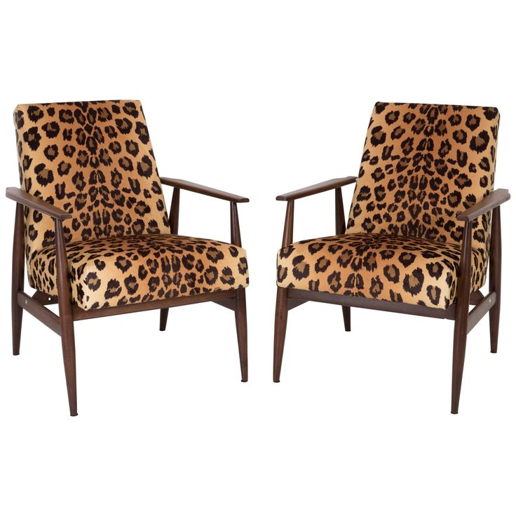 two chairs with leopard print upholstered on the back and arms, one in dark wood