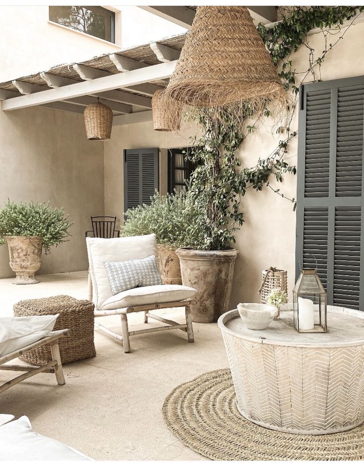 an outdoor patio with wicker furniture and potted plants