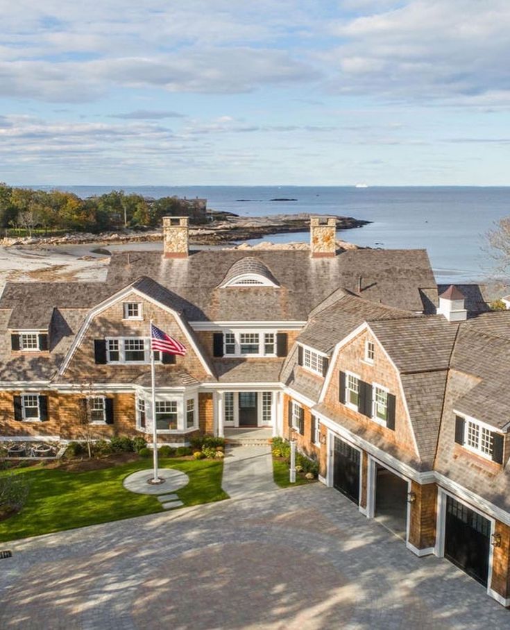 an aerial view of a large house with the ocean in the backgroung