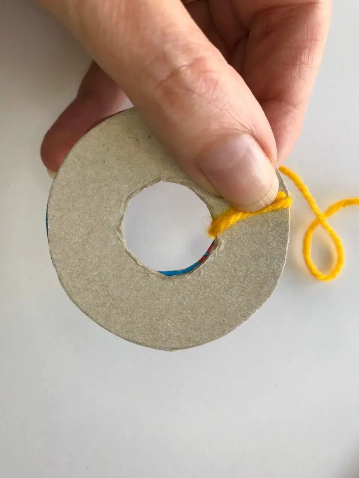 someone is making a paper circle with yarn