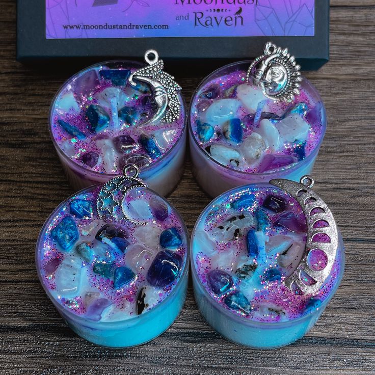 three blue and purple jewelry boxes sitting on top of a wooden table