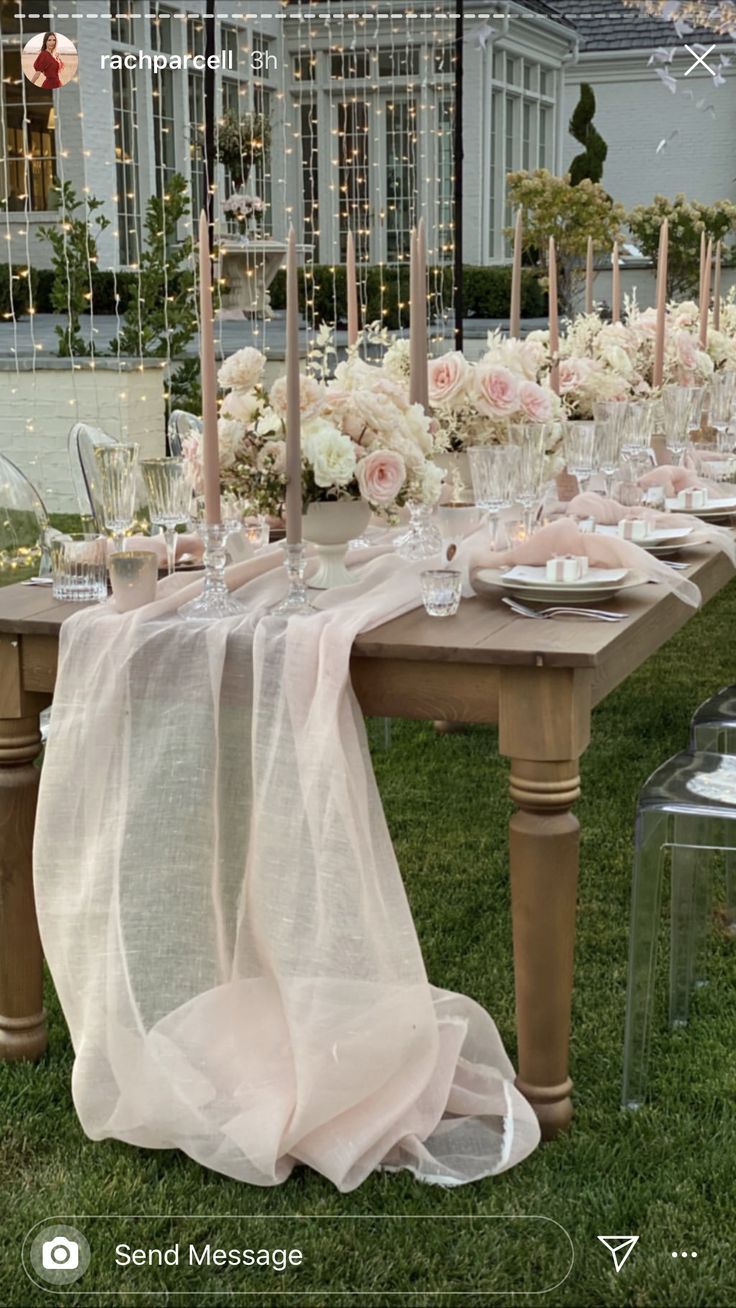 the table is set with candles, plates and flowers on it for an elegant dinner