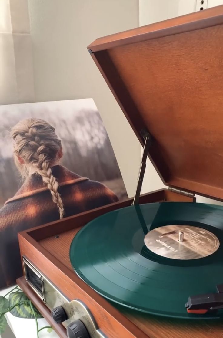 an old record player with a poster in the background