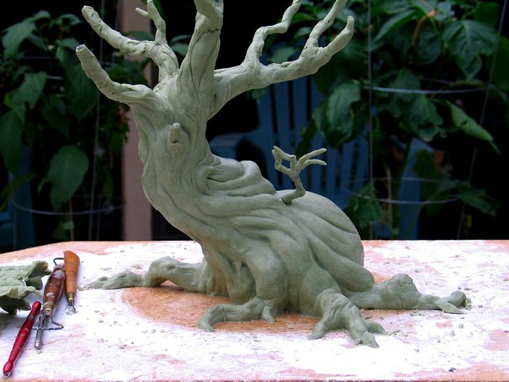 a clay tree sitting on top of a table next to some scissors and other items