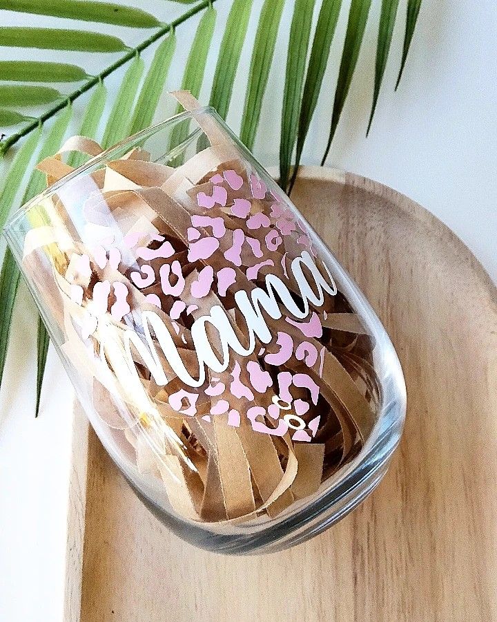 a glass jar filled with pink and white hearts on top of a wooden tray next to a palm leaf