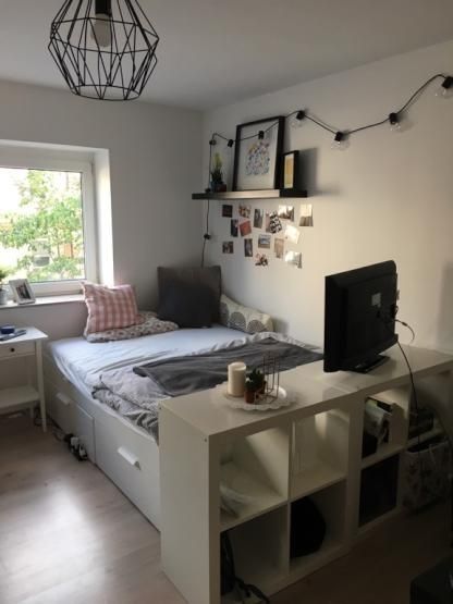 a bed room with a neatly made bed next to a window