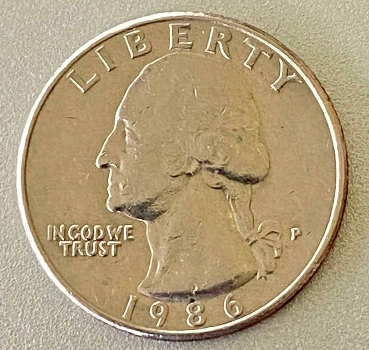 a close up of a coin on a white surface with the word liberty written in cursive writing