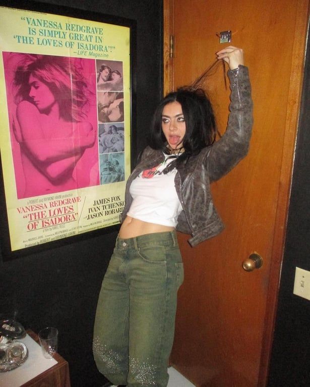 a woman standing on top of a toilet next to a poster