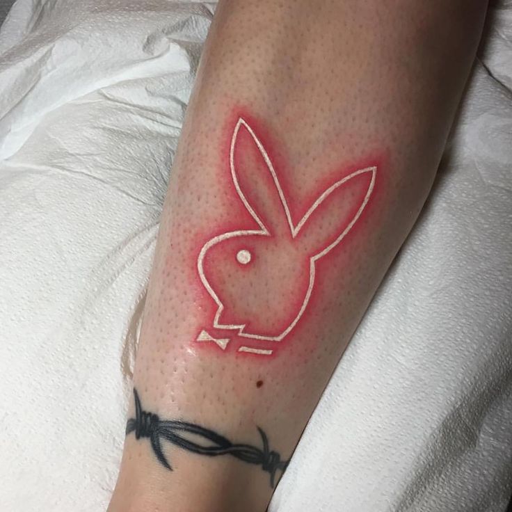 a person with a tattoo on their arm has a rabbit drawn on the side of his leg