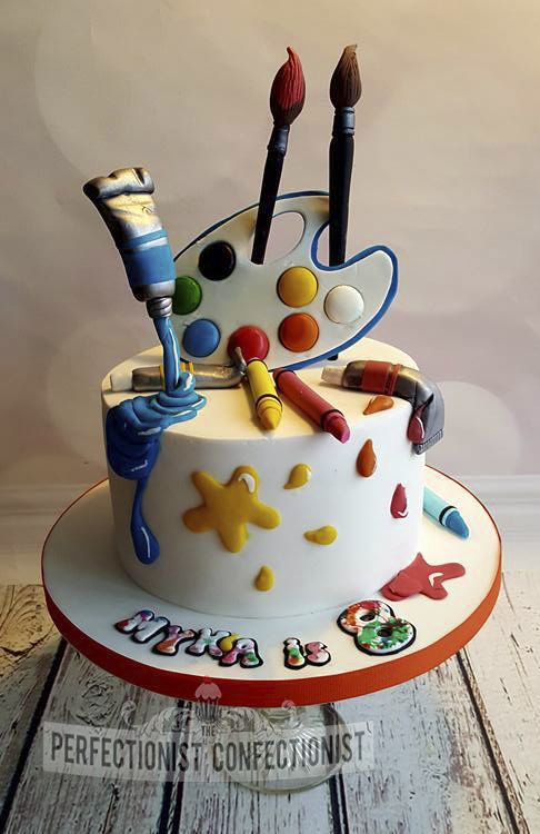 a birthday cake decorated with art supplies