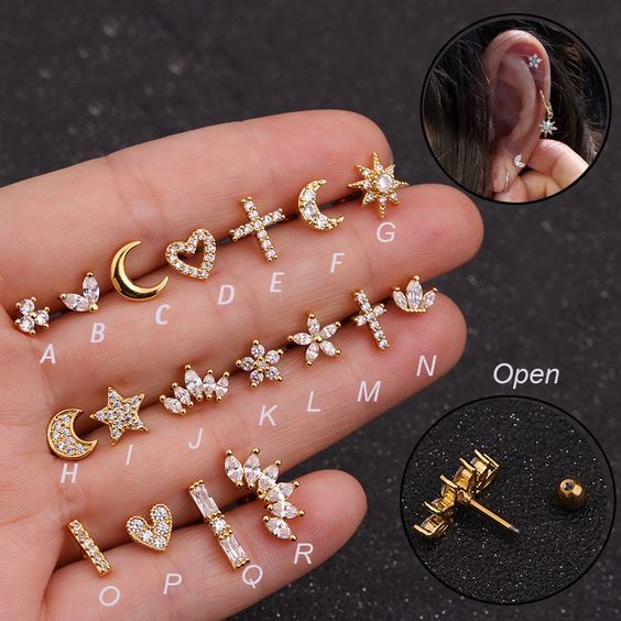 six pairs of ear studs with stars and moon designs on them, all in gold