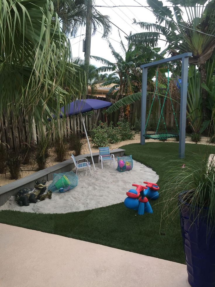 an outdoor play area with artificial grass and toys