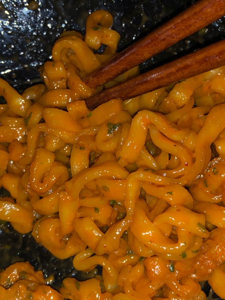 some food is cooking in a pan with chopsticks