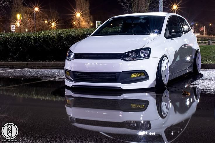 a white car is parked on the street at night