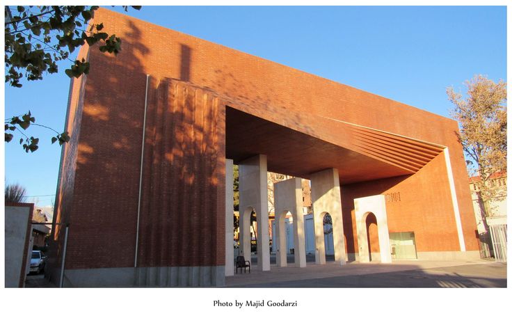 the entrance to an art museum with brick walls and arches on it's sides