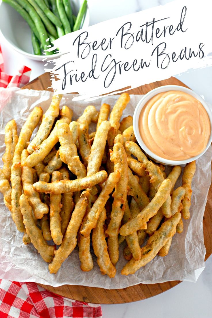 fried green beans on a plate with dipping sauce