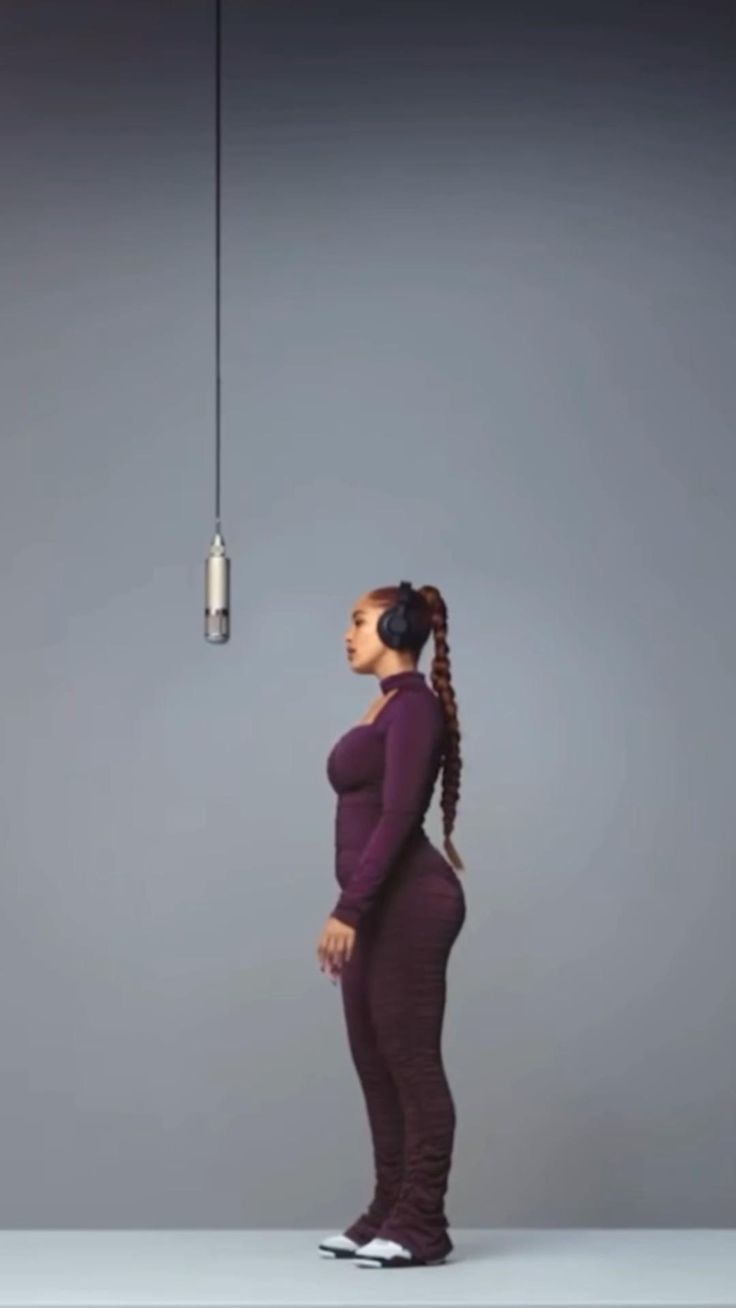 a woman standing in front of a light bulb with her head turned to the side