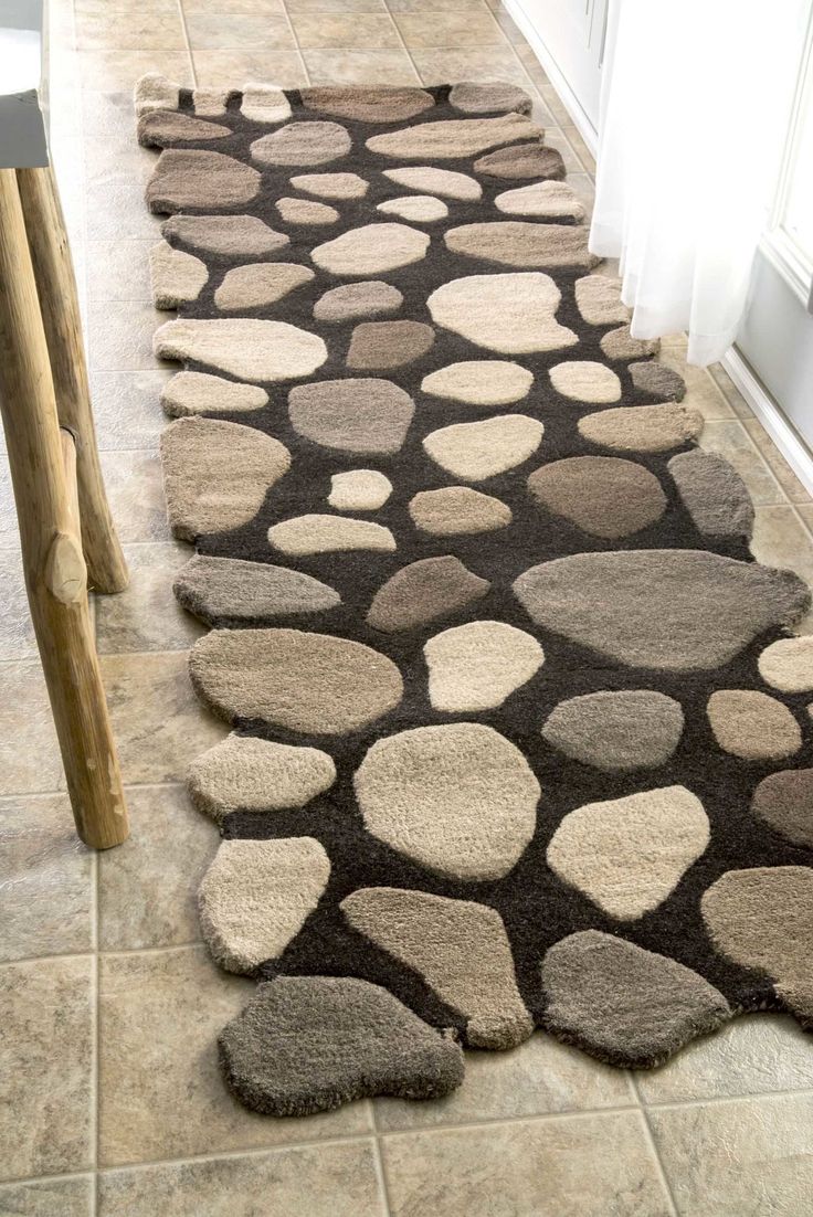 a brown and white rug on the floor in front of a door with an open window