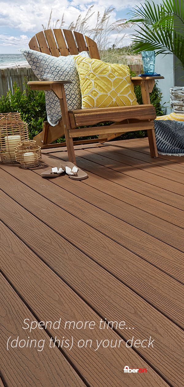 a bench sitting on top of a wooden deck next to a plant and potted plants