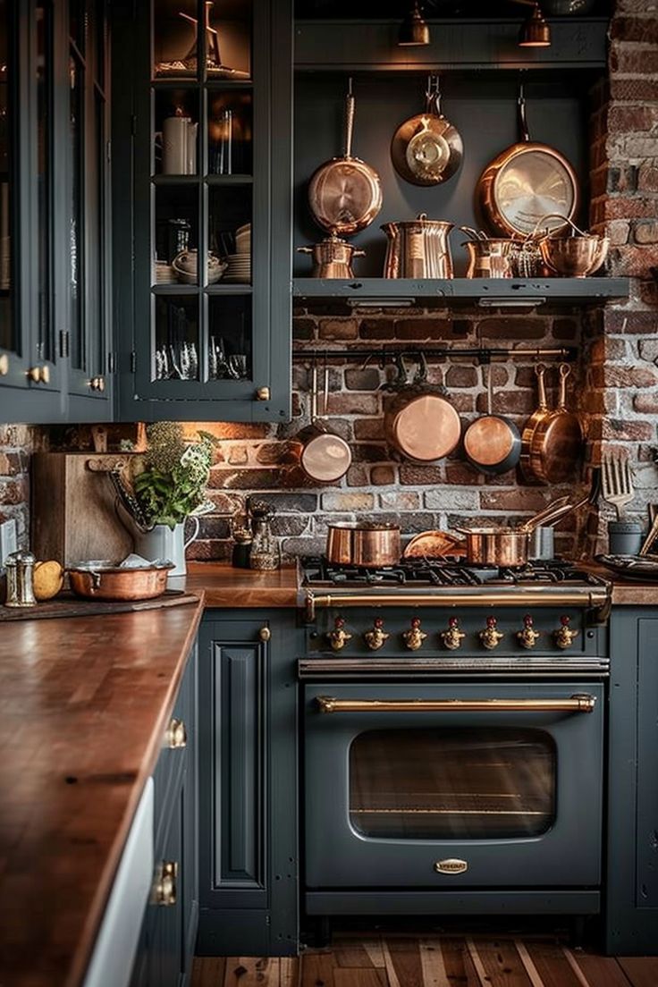 a kitchen with blue cabinets and copper pots on the wall, along with wooden counter tops