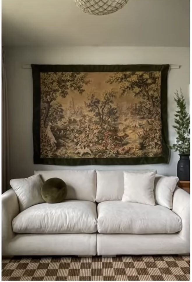 a white couch sitting in front of a painting on the wall