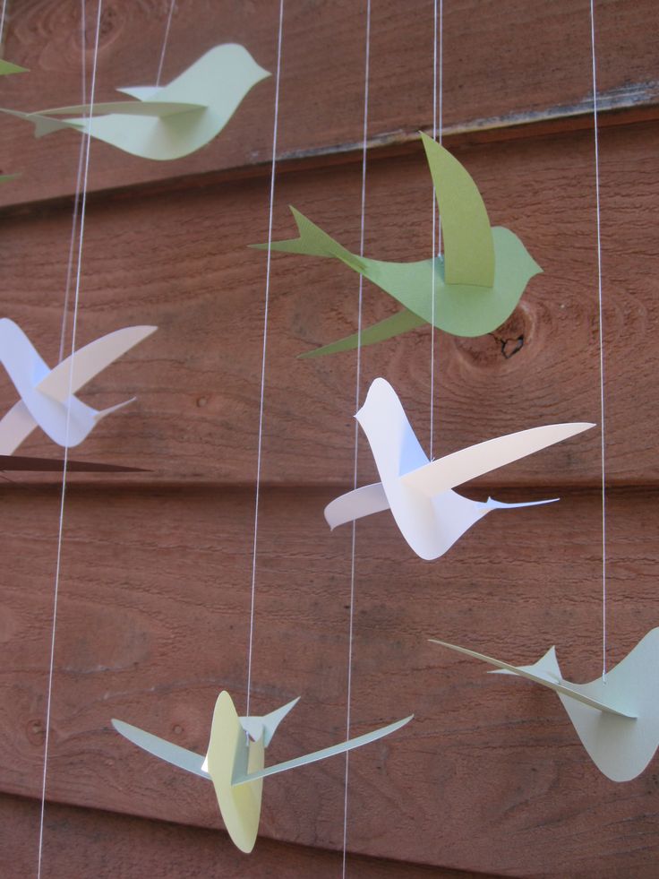 paper birds are hanging from the side of a house