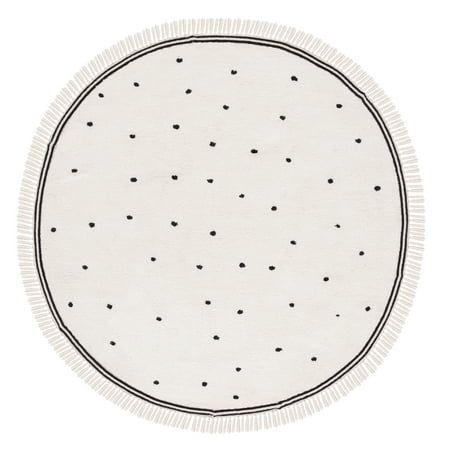 a round rug with black dots on white paper and fringe trim around the edges is shown