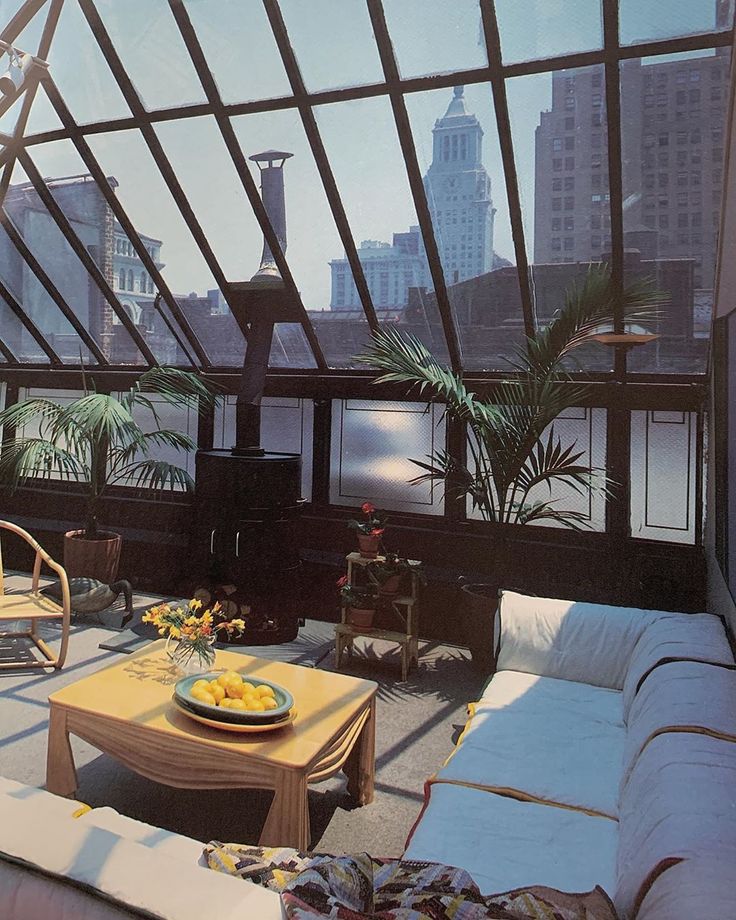 a living room filled with lots of furniture next to a tall cityscape in the background